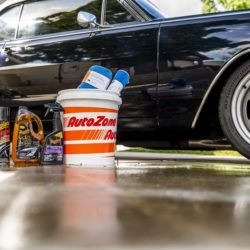 Car wash supplies in front of a shiny looking car.