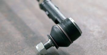 Tie rod end laying on top of the concrete.