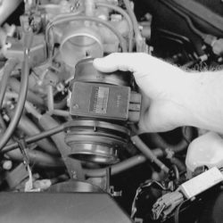 Person lifting a mass air flow sensor to show how to clean MAF.