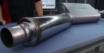 A Magnaflow muffler sitting on top of a shop table.