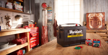 Duralast Gold battery sitting on a table in a workshop.