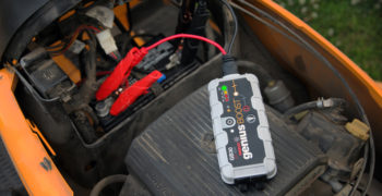 NOCO genius boost being used to show how to recharge a lawn mower battery