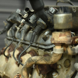 Close up image of an engine with four fuel injectors running along the fuel rail