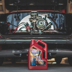 STP motor oil in front of a red classic car in the garage