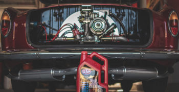 STP motor oil in front of a red classic car in the garage