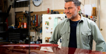 Man admiring his truck's hood after some paintless dent repair