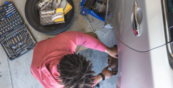 A man has grown tired of experiencing bad brakes symptoms, and now is removing the rotor to install new brakes