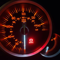 Close up of fuel gauge with its brake light on