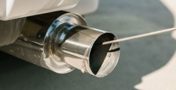 Close up of tailpipe while a car fails an emissions test