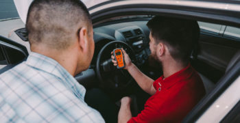 AutoZone associate showing the reading for P1000 to a customer on the Fix Finder scan tool
