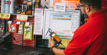 AutoZone associate consulting the FixFinder system to diagnose CEL P0440