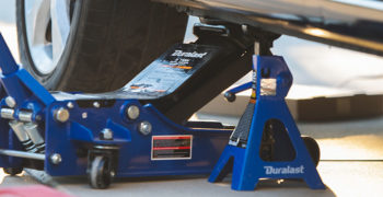 Car resting on a jack before receiving needed maintenance during tax time
